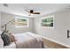 Bright bedroom with two windows, ceiling fan, and modern gray color scheme at 4041 Linwood St, Sarasota, FL 34232