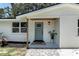 Close up of the home's front entry featuring a new door, porch tile, wood columns, and updated lighting at 4041 Linwood St, Sarasota, FL 34232