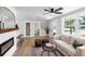 Open-concept living room with a fireplace, modern ceiling fan, and plenty of natural light at 4041 Linwood St, Sarasota, FL 34232