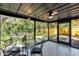 Screened patio with ceiling fan, dining table set and view of backyard and fire pit at 4041 Linwood St, Sarasota, FL 34232