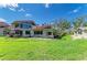 Spacious backyard with green grass, a patio area, and a charming house with red trim and large windows at 500 Park S Blvd # 97, Venice, FL 34285