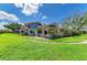 Well-maintained home featuring a lush green lawn, large windows and red trim against a bright, blue sky at 500 Park S Blvd # 97, Venice, FL 34285