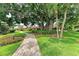 Scenic pathway through mature trees and manicured landscaping leading to charming residences at 500 Park S Blvd # 97, Venice, FL 34285