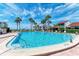 Inviting outdoor pool surrounded by palm trees, lounge chairs and community buildings on a sunny day at 500 Park S Blvd # 97, Venice, FL 34285