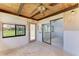 Enclosed sunroom featuring a wooden ceiling, large windows, sliding glass door and a ceiling fan at 500 Park S Blvd # 97, Venice, FL 34285