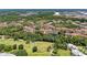 Wide aerial view of community featuring golf course, lush landscaping, and a lake at 5001 Baraldi Cir # 22-202, Sarasota, FL 34235
