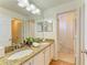 Bathroom showcasing double vanity, white cabinetry, granite countertops, and an adjacent shower at 5001 Baraldi Cir # 22-202, Sarasota, FL 34235