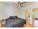 Bedroom featuring a ceiling fan, neutral walls, wood floors, and views to attached bath at 5001 Baraldi Cir # 22-202, Sarasota, FL 34235