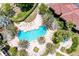 Aerial view of community pool surrounded by palm trees, lounging area and lush landscaping at 5001 Baraldi Cir # 22-202, Sarasota, FL 34235