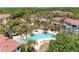Aerial view of community pool featuring palm trees, lounge chairs, and spa at 5001 Baraldi Cir # 22-202, Sarasota, FL 34235
