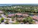 Community building with vibrant landscaping, a pond, and ample parking at 5001 Baraldi Cir # 22-202, Sarasota, FL 34235