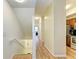 Bright hallway with wood floors leading to the kitchen area, front door and a stairwell at 5001 Baraldi Cir # 22-202, Sarasota, FL 34235