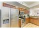 A kitchen showcasing stainless steel appliances, wood cabinets, and a granite countertop at 5001 Baraldi Cir # 22-202, Sarasota, FL 34235