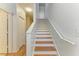 Stairwell with wood treads, white risers, and a white handrail leading to the second floor at 5001 Baraldi Cir # 22-202, Sarasota, FL 34235