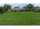 View of a backyard featuring a large lawn with a screened-in pool and beautiful home at 5012 Cherry Laurel Way, Sarasota, FL 34241