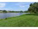 Lake view from the backyard with a grassy bank and a small dock at 5012 Cherry Laurel Way, Sarasota, FL 34241