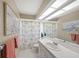 Bright bathroom with a white vanity, tile flooring, and a shower with a patterned curtain at 5012 Cherry Laurel Way, Sarasota, FL 34241