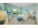 Stylish bedroom with blue walls, white furnishings, and natural light from a large window at 5012 Cherry Laurel Way, Sarasota, FL 34241