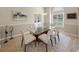 Bright dining room featuring a glass table, six chairs, modern lighting, and neutral decor at 5012 Cherry Laurel Way, Sarasota, FL 34241