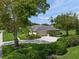 A charming single-story home with an attached garage, lush landscaping, and mature trees surrounding it at 5012 Cherry Laurel Way, Sarasota, FL 34241