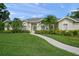 A well-manicured lawn and paved walkway lead to the front door of this single-story home at 5012 Cherry Laurel Way, Sarasota, FL 34241