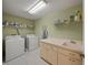 Functional laundry room with washer, dryer, sink, and ample storage space at 5012 Cherry Laurel Way, Sarasota, FL 34241