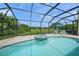 A screened-in pool and spa with a beautiful backyard and lake view at 5012 Cherry Laurel Way, Sarasota, FL 34241