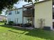 Apartment complex featuring a grassy yard with a wooden balcony and patio furniture at 5026 Water Oak Dr # 114, Bradenton, FL 34207