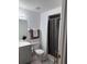 Bathroom features a vanity, toilet, mirror, towel rack and walk-in shower with gray shower curtain at 5026 Water Oak Dr # 114, Bradenton, FL 34207