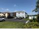 View of a two-story condominium building with parking, landscaping, and mailbox area under a sunny blue sky at 5026 Water Oak Dr # 114, Bradenton, FL 34207