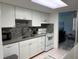 Bright kitchen with white cabinets, stainless steel sink, mosaic backsplash and modern appliances at 5026 Water Oak Dr # 114, Bradenton, FL 34207