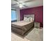 A bedroom with a purple accent wall, a ceiling fan, and gray furniture at 5026 Water Oak Dr # 114, Bradenton, FL 34207