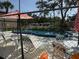 Community pool area enclosed by a chain-link fence with lounging chairs and umbrellas at 5026 Water Oak Dr # 114, Bradenton, FL 34207