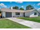 Charming single-story home with a well-manicured lawn, a gray garage door, and fresh landscaping at 5032 Barcelona Ave, Sarasota, FL 34235