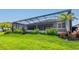 Lush backyard with well-manicured lawn and screened lanai, perfect for outdoor living and entertaining at 5533 Long Shore Loop, Sarasota, FL 34238