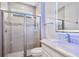 Modern bathroom with glass enclosed shower, decorative accent tiles, white marble countertop, and backlit mirror at 5533 Long Shore Loop, Sarasota, FL 34238