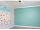 Neutral bedroom with gray floors, turquoise accent wall, white crown moulding, and a ceiling fan at 5533 Long Shore Loop, Sarasota, FL 34238