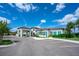 Modern community clubhouse with a porte-cochere entrance, ample parking, and manicured landscaping at 5533 Long Shore Loop, Sarasota, FL 34238