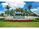 Beautiful community entrance with stone signage, lush landscaping, and fountain features under a bright blue sky at 5533 Long Shore Loop, Sarasota, FL 34238