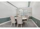 Dining room with a round table and six chairs, stylish lighting, and large window at 5533 Long Shore Loop, Sarasota, FL 34238