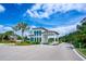 Elegant white guard house with blue awnings, a covered entrance, and professionally landscaped grounds at 5533 Long Shore Loop, Sarasota, FL 34238