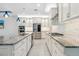 Modern kitchen with stainless steel appliances, white cabinets, granite countertops, and tile backsplash at 5533 Long Shore Loop, Sarasota, FL 34238