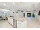 Bright kitchen with white cabinets, stainless steel appliances, and a large center island with granite countertops at 5533 Long Shore Loop, Sarasota, FL 34238
