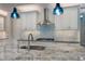 The island kitchen features granite countertops, updated stainless appliances, and pendant lights at 5533 Long Shore Loop, Sarasota, FL 34238