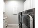 Modern laundry room featuring gray front load washer and dryer set with white cabinets at 5533 Long Shore Loop, Sarasota, FL 34238