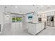 Open-concept living room with tile floors, island kitchen, and sliding glass doors to the pool area at 5533 Long Shore Loop, Sarasota, FL 34238