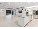 Open-concept living space with tile floors, kitchen island, stainless steel appliances, and views of pool at 5533 Long Shore Loop, Sarasota, FL 34238