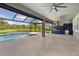 Covered patio with summer kitchen and ceiling fans overlooking a swimming pool, and tranquil lake at 5533 Long Shore Loop, Sarasota, FL 34238