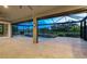 Spacious screened lanai with travertine flooring, offering serene views of the pool, water features, and landscaping at 5533 Long Shore Loop, Sarasota, FL 34238