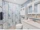 Charming bathroom with blue accents, decorative shower curtain, and ample storage space at 5891 Welcome Rd # I6, Bradenton, FL 34207